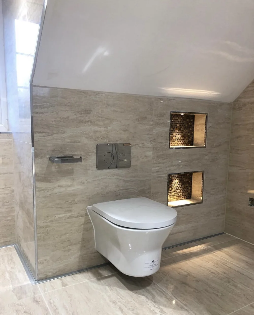 Travertine wet room with wall-hung WC and illuminated mosaic niches — bathroom renovation