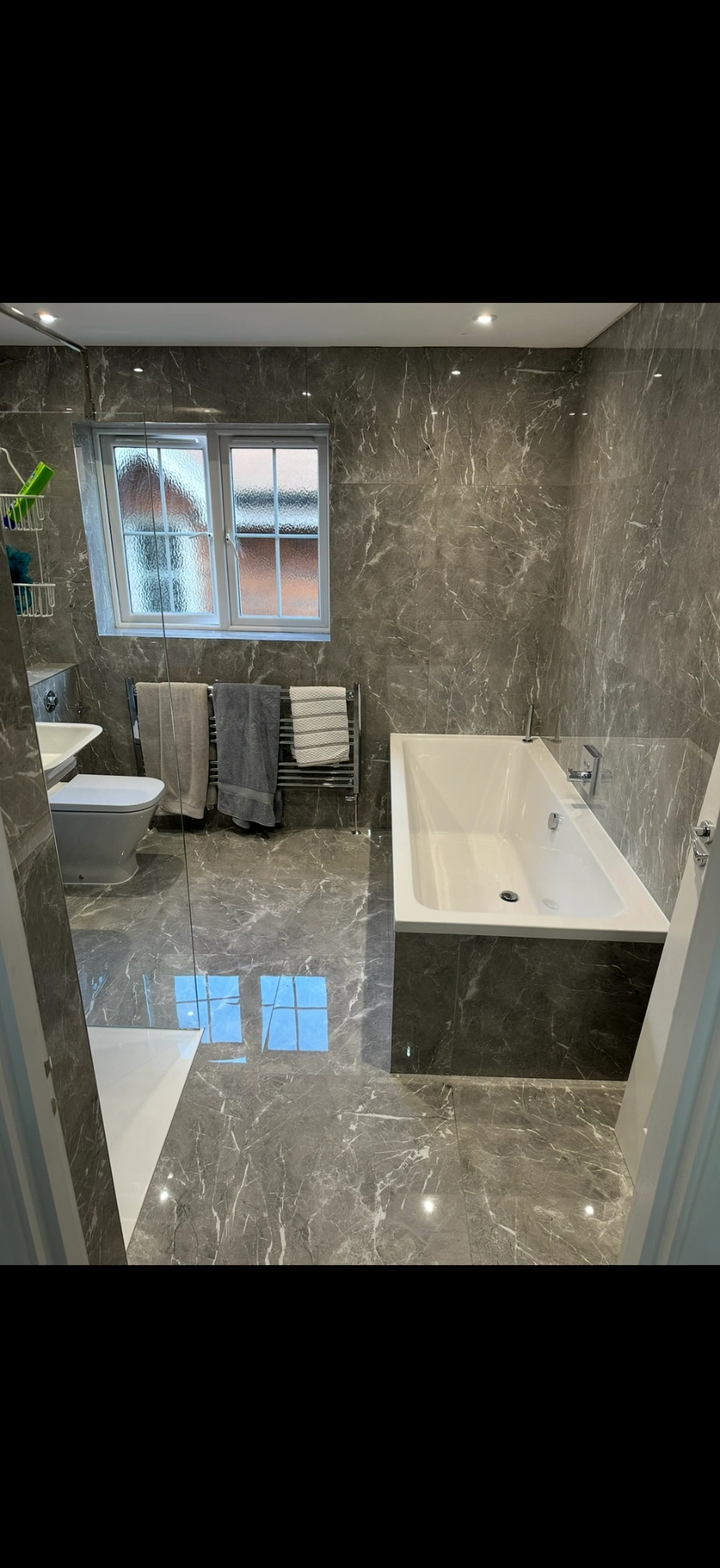 Grey marble family bathroom with bath, walk-in shower and heated towel rail